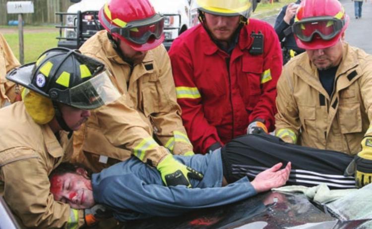 SVFD personnel (from left) Travis Leihardt, Josh Berckenhoff, Caleb Geissen, and Mike Czimskey remove the “deceased” body of Kael Baumgarten from one of the vehicles. Sticker Photo By Darrell Vyvjala