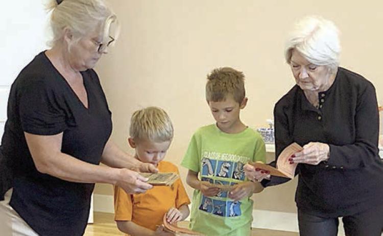 An ancest or’s Czech books of pl ays were brought by Dominik Woodworth (second from left) and Zander Woodworth (second from right) along with their grandmother Taffy Danner (left) and greatgrandmother Betty Danner (right).