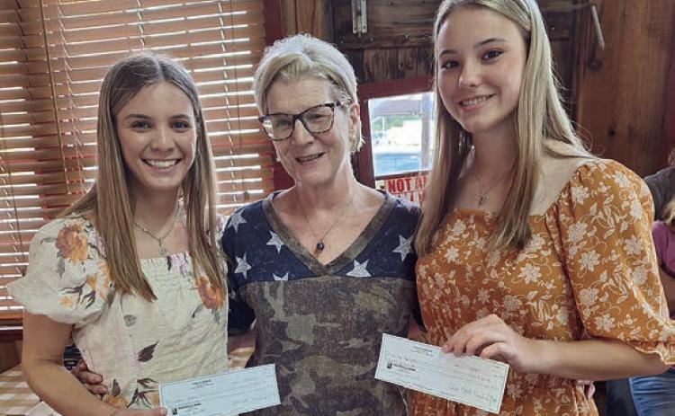 Scholarship recipients Jordan Whitley (left) of Hallettsville and Delaney Turlington (right) of Weimar are congratulated by Hermann Sons Life Lodge 14 scholarship chair Mary K. Seifert (center).
